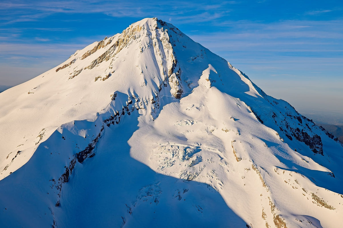 Strong shadow tracing the crags of Mount Hood's summit ridge under a deep blue sky